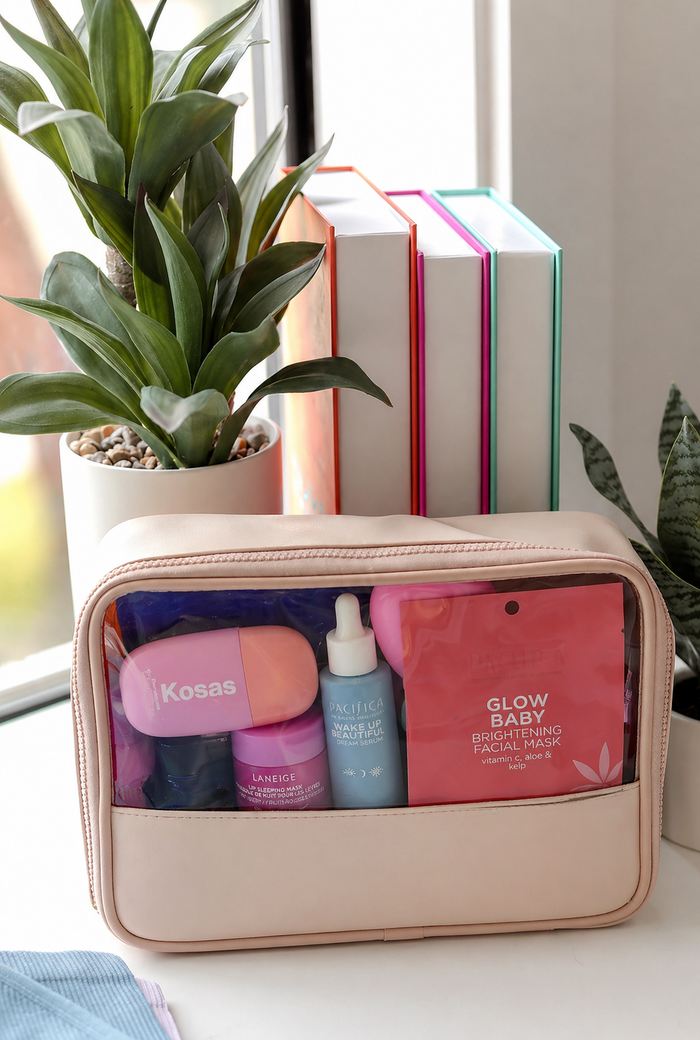 Cosmetic bag with skincare products on a desk with plants and books in the background