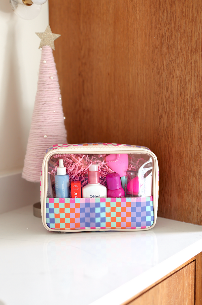 Colorful cosmetic bag with skincare products, featuring a clear top and checkered design.
