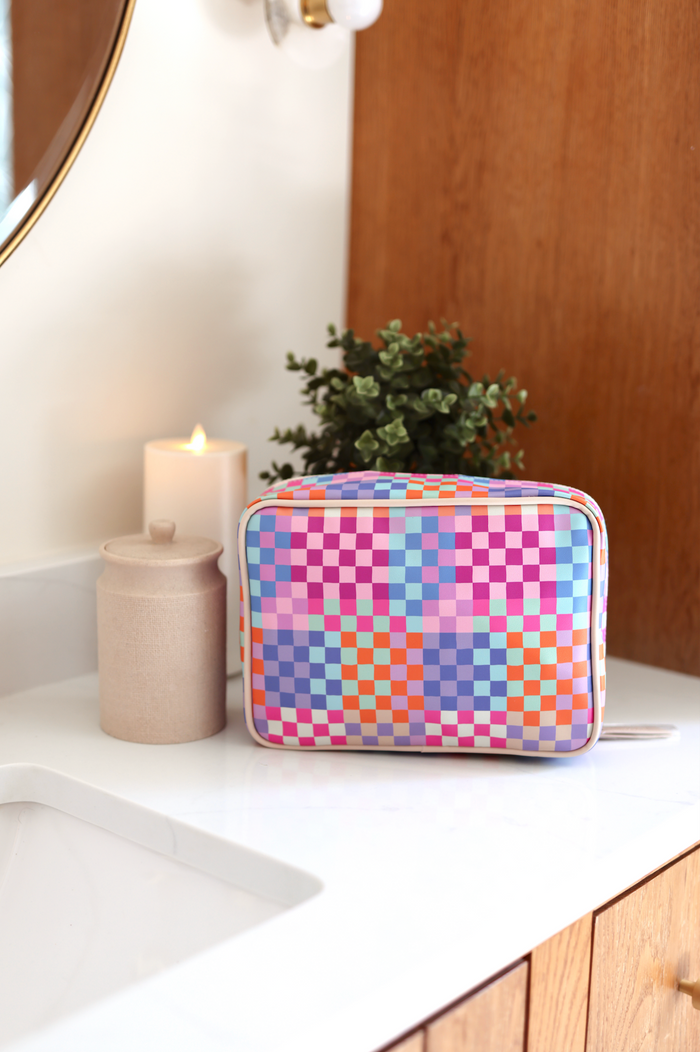 Colorful checkerboard cosmetic bag in pastel shades, ideal for makeup and travel essentials.
