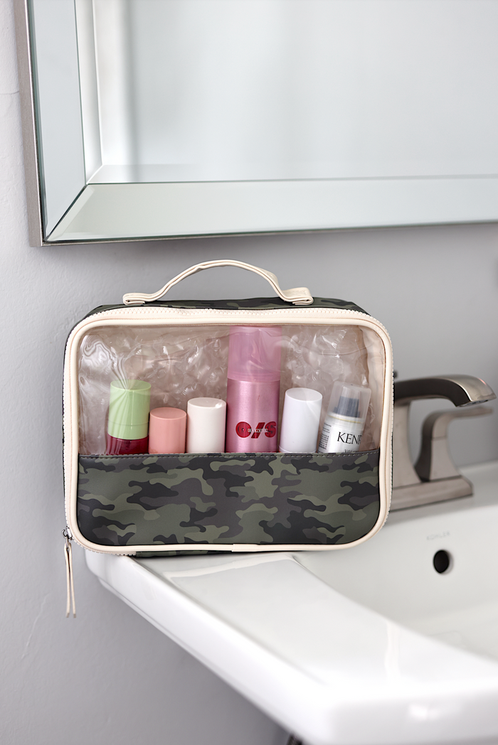 Camouflage travel toiletry bag with clear top, featuring multiple compartments for organization.