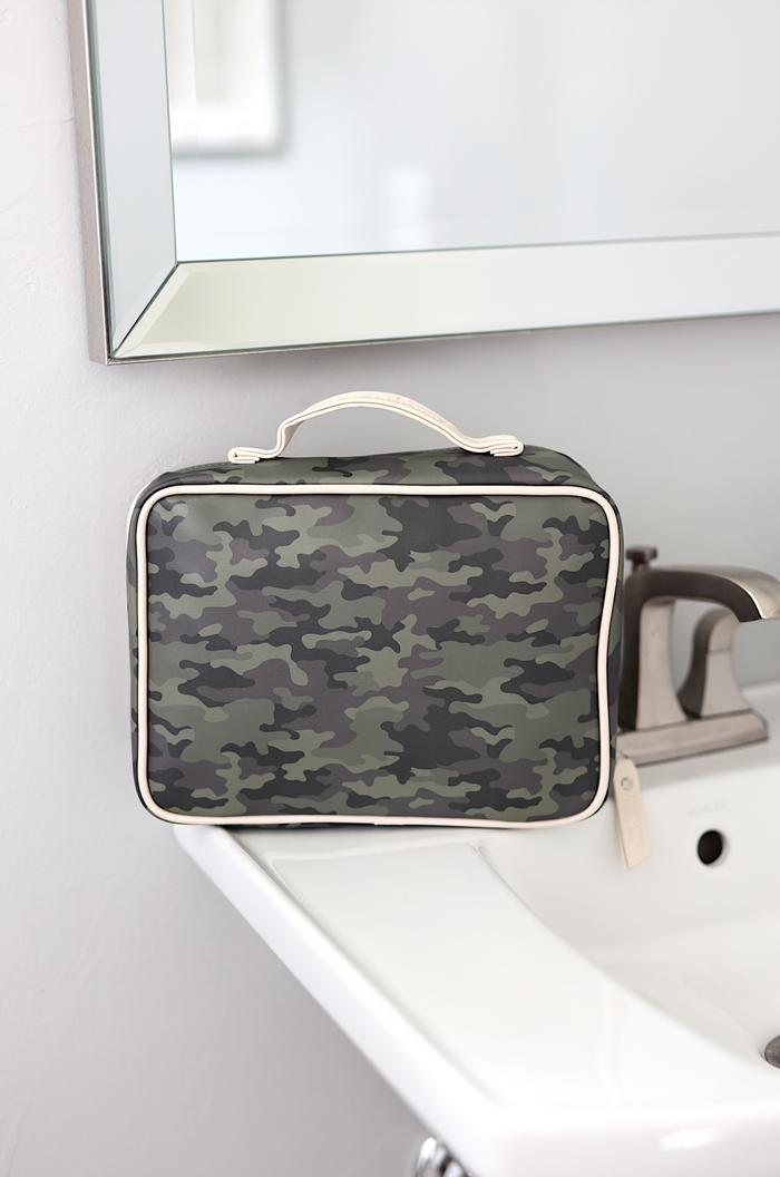 Camouflage travel toiletry bag with cream trim, ideal for organizing personal items.