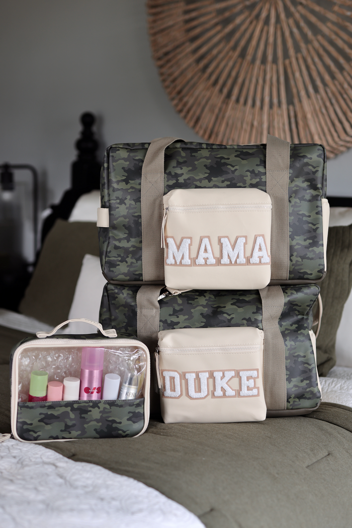 Stylish camo diaper bags in green and beige with 'MAMA' and 'DUKE' embroidery, featuring a transparent cosmetic pouch.