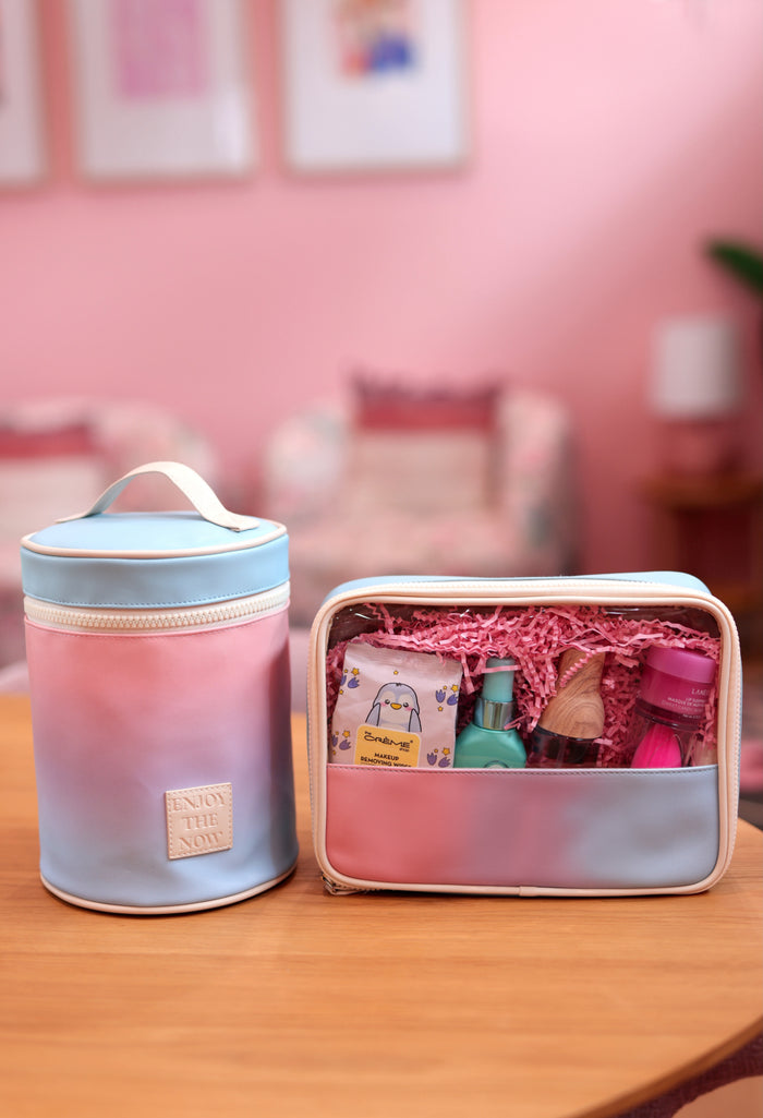 Two pastel gradient cosmetic bags with various beauty products inside on a wooden table.
