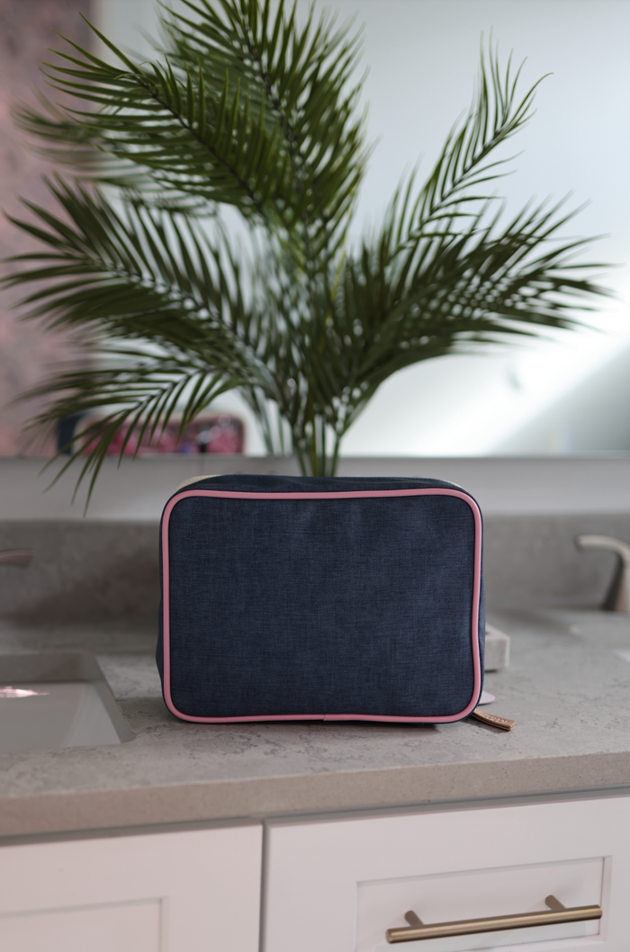 Navy blue toiletry bag with pink trim, durable material, ideal for travel and organization.