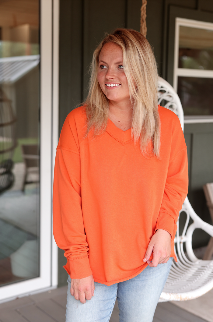 Vibrant orange oversized V-neck sweatshirt in soft fabric, perfect for casual outfits and comfortable wear.