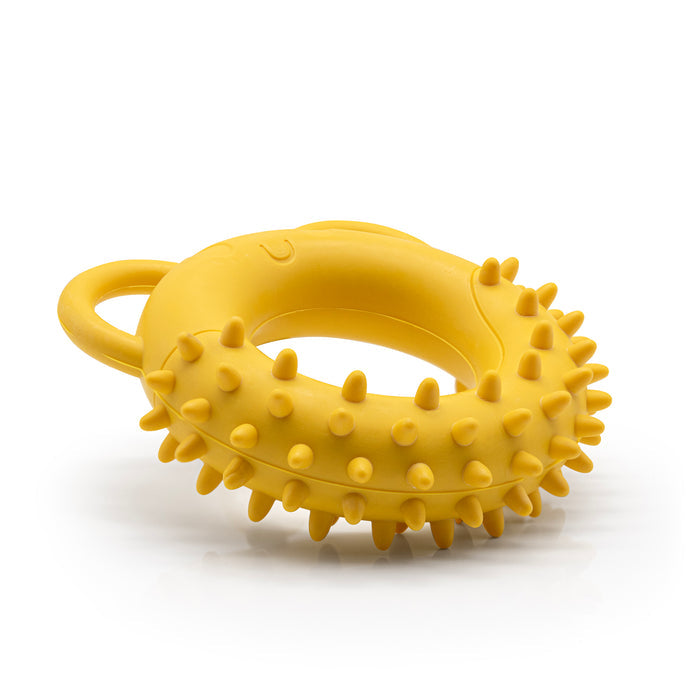 Yellow Fairtrade rubber tug toy shaped like a spikey doughnut with ears for handles on a white background.