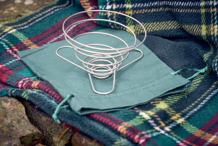Portable wire coffee dripper on top of green organic cotton carry pouch
