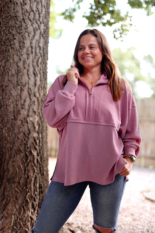 Cozy pink quarter-zip pullover with a soft waffle knit texture and relaxed fit, perfect for casual wear.