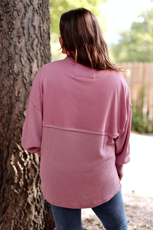 Cozy pink oversized sweater with textured fabric, perfect for casual wear in any season.