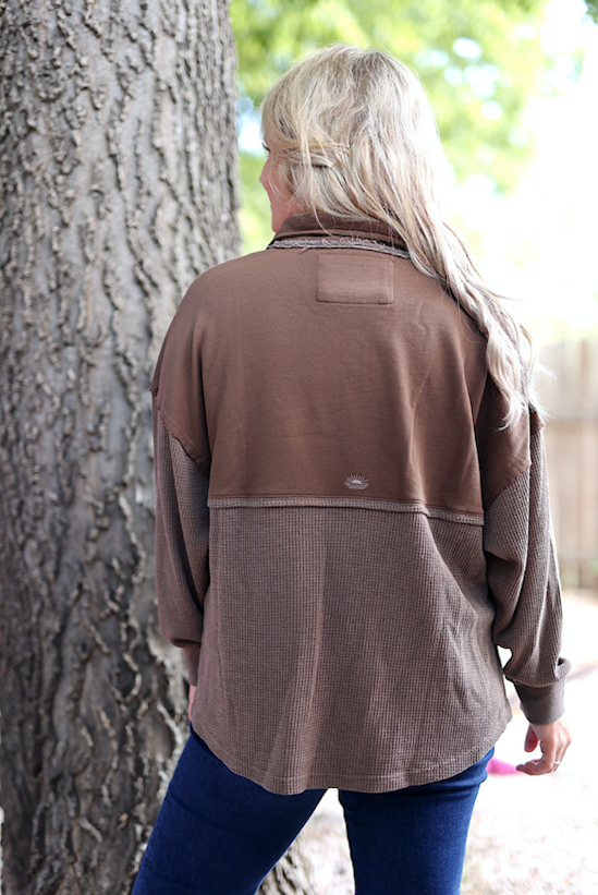 Brown oversized pullover sweater with textured fabric and relaxed fit, perfect for casual wear.