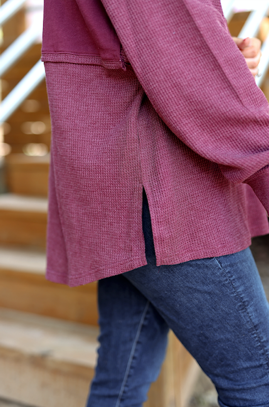 Women's maroon oversized waffle knit sweater with side slits, perfect for casual layering.
