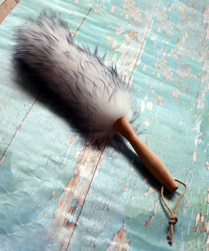 Lambswool duster with a solid beechwood handle on a textured blue surface