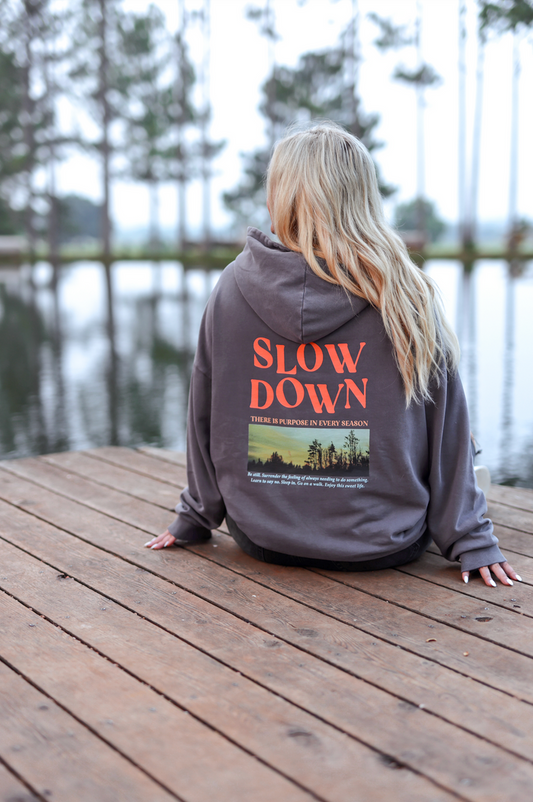 Cozy grey hoodie with 'SLOW DOWN' graphic, perfect for casual wear and relaxation.