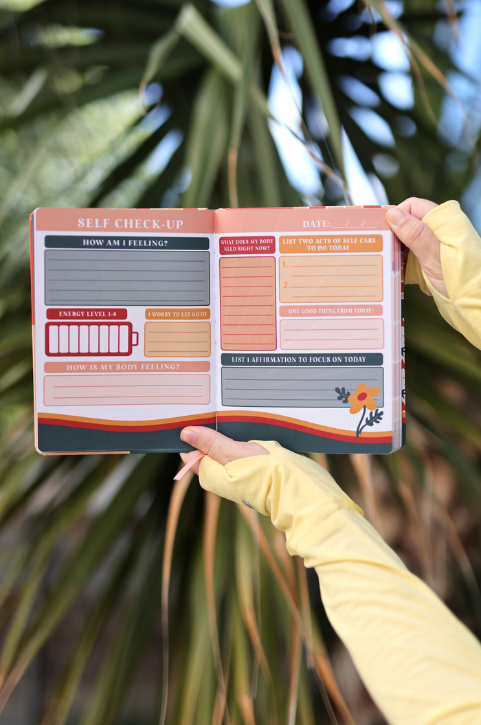 Open self-check-up journal with prompts, colorful pages, and emotional wellness sections.