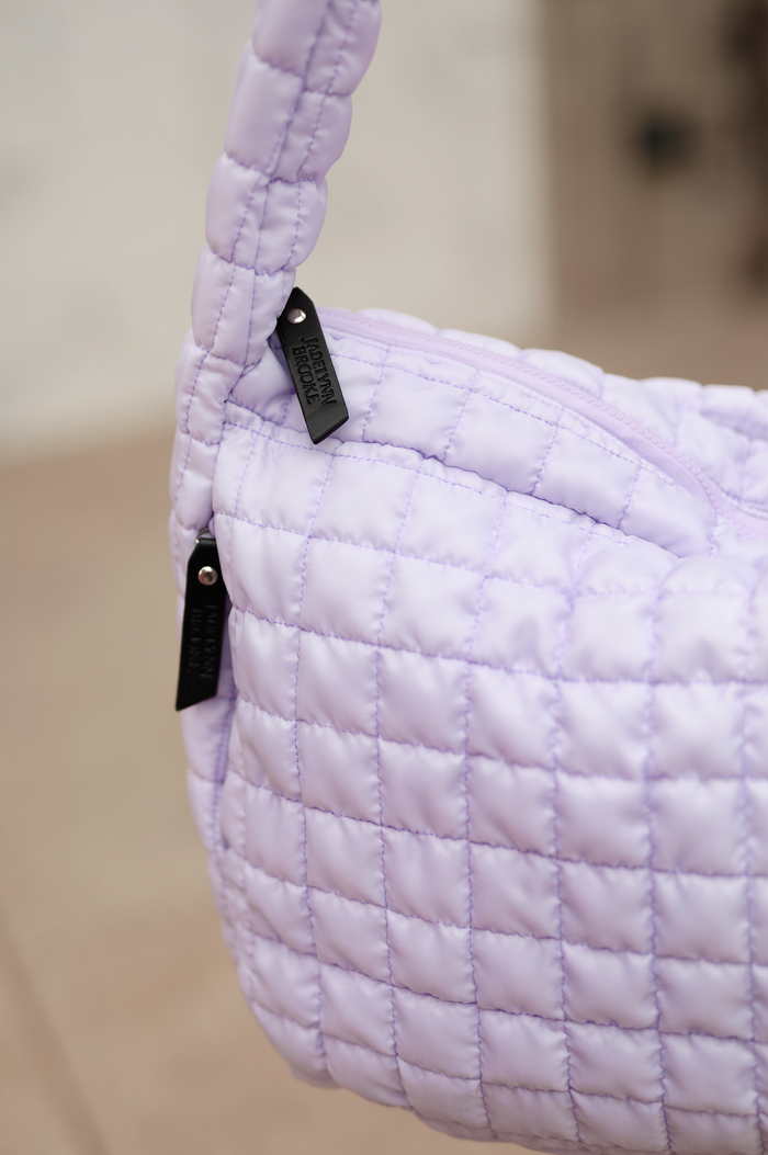 Light purple quilted handbag with branded tags, stylish and functional for everyday use.