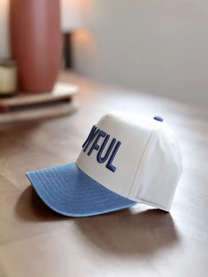 Stylish white and blue baseball cap with embroidered text, made for casual wear and sun protection.