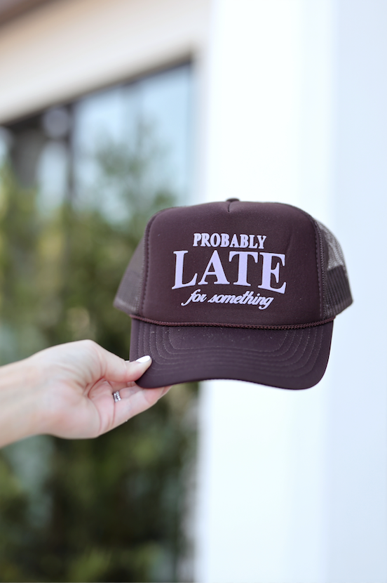 Brown trucker hat with "PROBABLY LATE for something" embroidered text, stylish and casual accessory.