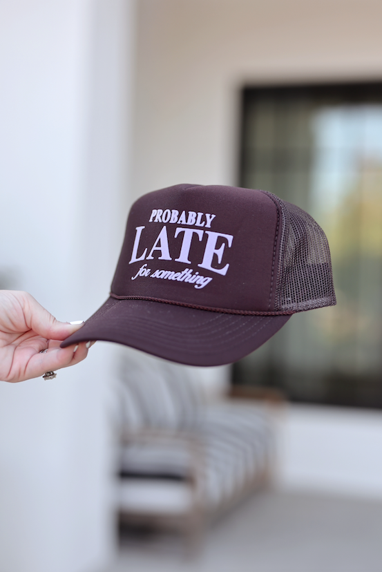 Brown trucker hat with 'Probably Late for Something' text, perfect for casual outings.